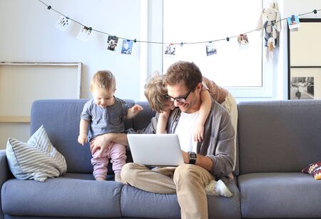 Father and little sons are playing on the sofaの写真素材
