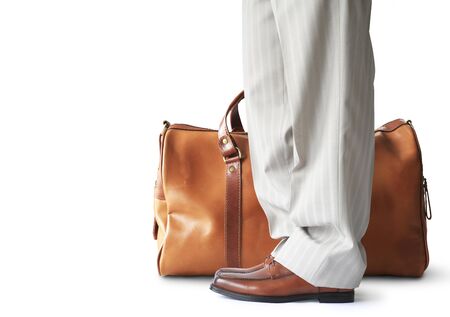 Man is standing with a large brown leather bagの写真素材