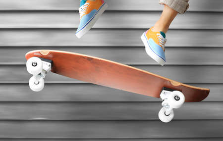 Skateboarder in colored sneakers jumping on a skateboardの写真素材