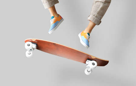 Skateboarder in colored sneakers jumping on a skateboardの写真素材