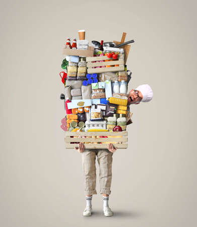 Cheerful chef keeps a huge pile of vegetables and other productsの写真素材