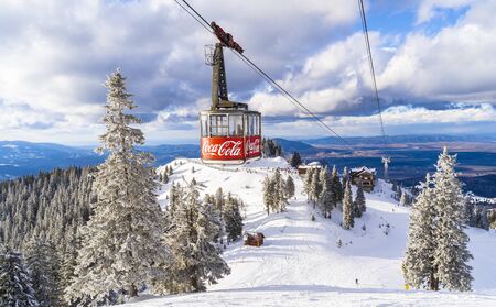 Brasov, Romania - February 12, 2020: Aerial view of the famous ski slope in Poiana Brasov  with greatest Coca Cola company imprinted on cable car reaching high altitudeのeditorial素材