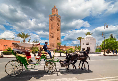 Horse carriage with passenger in front of  Koutoubia Mosque on Marrakesh, Moroccoのeditorial素材