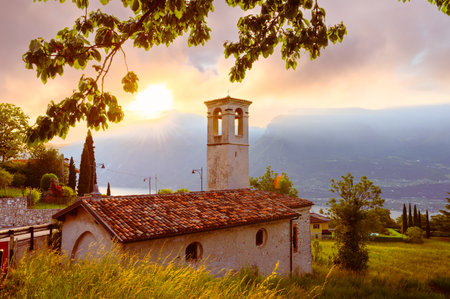 Landscape with little church at sunrise in Limone sul garda town, Garda Lake, Italyの写真素材