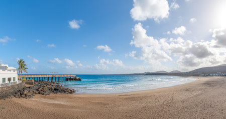 Landscape with Arrieta Beach in Lanzarote, Canary Islands, featuring a sandy shore, crystal-clear waters, and stunning coastal viewsの写真素材