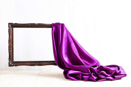 Purple satin curtains unveiling a levitating brown empty frame, on white background, wallpaper design, podium pedestal , luxury advertising displayの写真素材