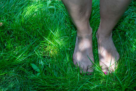 Middle aged woman practicing earthing, also referred to as grounding (an age-old practice that involves connecting your body, mind and spirit to the planet.)の写真素材