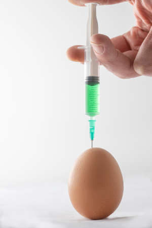 injecting an egg with green toxic substance, metaphorの写真素材