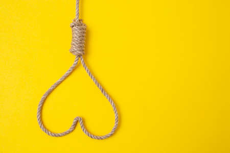 Jute rope forming a heart from a hangman noose on illuminating yellow backgroundの写真素材