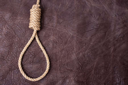 hangman's knot on brown textured leather backgroundの写真素材