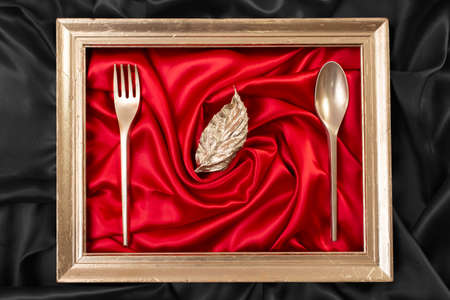 dining background concept with red satin and golden frame, close up
