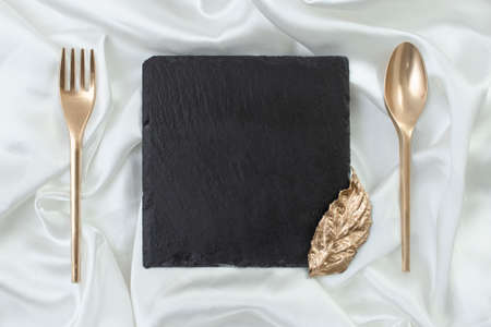 Elegant brochure mockup for restaurant presentation or menu. Square black stone tile with golden...