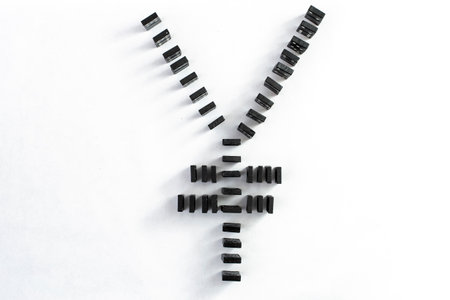 chinese currency symbol  made with black domino tiels,  isolated on white background.  Market volatility concept.の写真素材