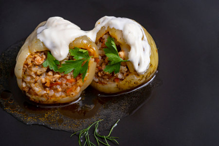 2 stuffed yellow bell peppers, with minced pork meat, rice, carrots and onion, sour cream on top,...