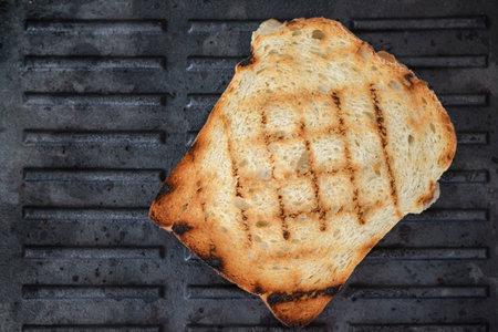 slice of bread on a cast iron grill, close up