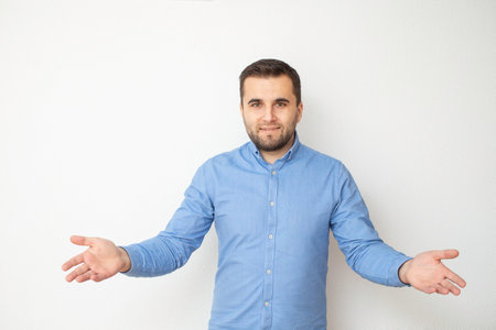 Caucasian male model smiling with opened arms and dressed in blue denim shirt