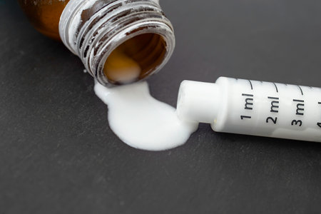 empty bottle of antibiotic reconstructed white substance with a dosage syringe on black background, soft focus close upの写真素材