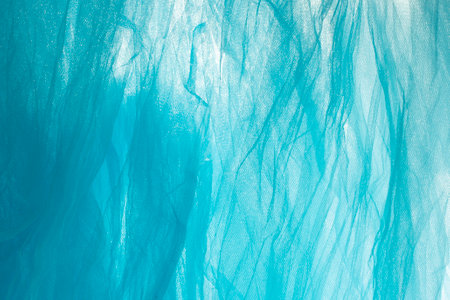 Thin bright blue fabric, soft focus close up, abstract textured backdropの写真素材