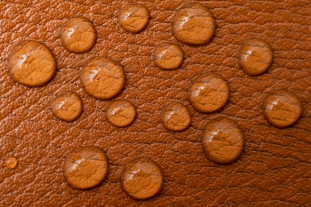 Round water drops on brown leather texture, soft focus close up patternの写真素材