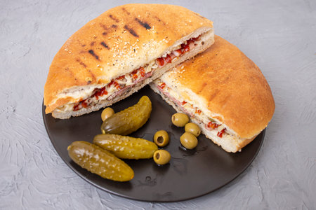 Pita bread sandwich with pickles and olives on gray cement backgroundの写真素材