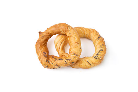 Pair of two pretzels with poppy seeds, close up isolated on white background