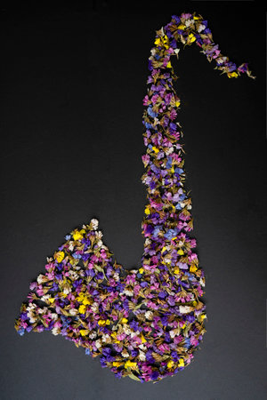 Saxophone made of dried flowers, isolated on black, creative conceptの写真素材