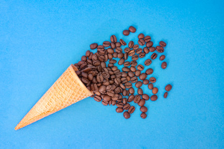 ice cream cone with coffee beans isolated on a blue backgroundの写真素材