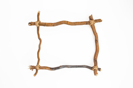 Willow tree branches tied with jute rope , in form of a frame, close up isolated on white background