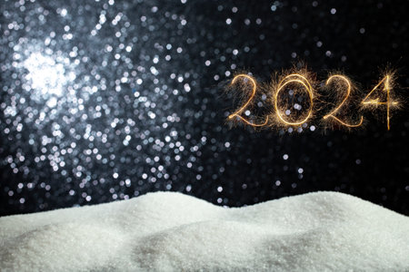 2024 number written with golden sparks fireworks and white crystals on black glitter background....