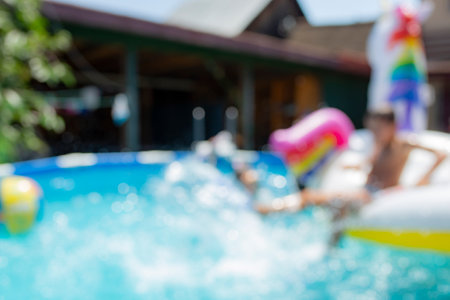 Blurred defocused photography of kids in a house pool, summer holyday backgroundの写真素材