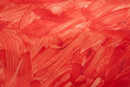 Red paint splatter and brush strokes on paper texture, close upの写真素材