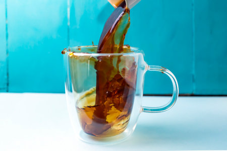 pouring coffee in a double glass mug, motion blur and soft focus close upの写真素材