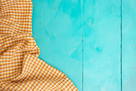 Orange checkered cloth on wooden blue boards table background, copy space for product placementの写真素材