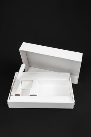 Empty smartphone or tablet box, white cardboard packaging isolated on black