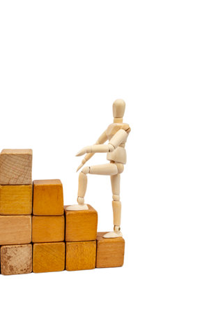 Wooden mannequin climbing on wood blocks stair, isolated on white backgroundの写真素材