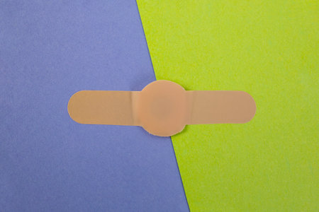 plastic bandadge connecting purple and green paperの写真素材