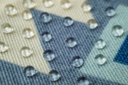 Clear water drops on patterned canvas, soft focus close upの写真素材