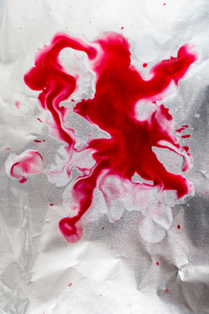 Red blood splatter on silver steel surface, soft focus close up,  backdrop