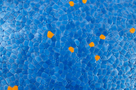 Blue styrofoam  structure with orange dots, abstract textured pattern