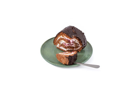 Chocolate roll with cheese and forest fruits filling on a ceramic plate, isolated on  whiteの写真素材