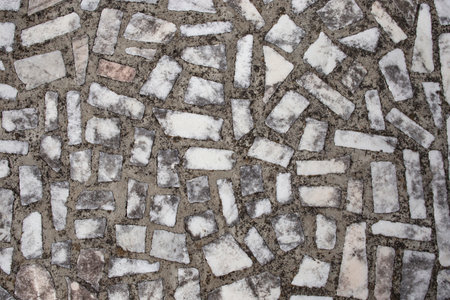 Rectangular white marble pieces on cement, aged mosaic structure