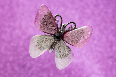 Epoxy resin Butterfly with wires and thread texture levitating on pink glitter background, soft focusの写真素材