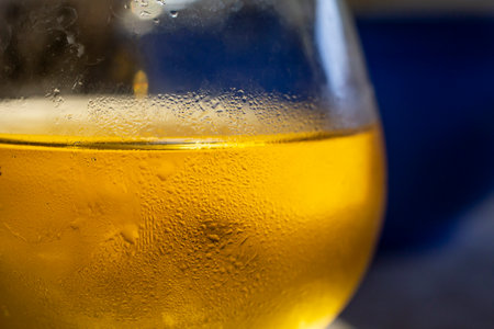 Curved beer glass condensation , golden texture soft focusの写真素材