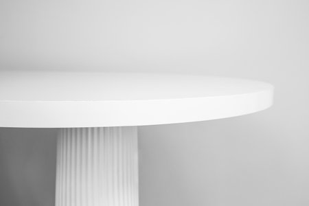 White round table top with column leg, side view on gray wall background, minimal backdrop for product presentation or display, soft focusの写真素材