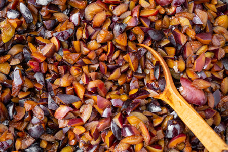 Chopped raw plums boiling for jam cooking process, with a   spoonの写真素材