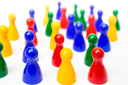 Red , yellow, blue and green pawns or pieces from a board game isolated on white backgroundの写真素材