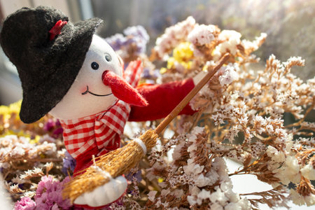 Colorful shot of a dried bouquet of purple limonium sinuatum flowers with a snow man figurine, soft focusの写真素材