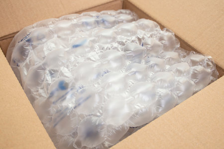 Cushion bubble wrap foil in a opened cardboard box, close up, abstract backdropの写真素材