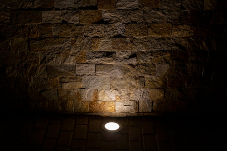 Decorative stone bricks illuminated with sidewalk floor lights, abstract backdropの写真素材