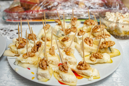 Finger food plate with walnut halves, cheese cubes and apple slices on toothpicksの写真素材